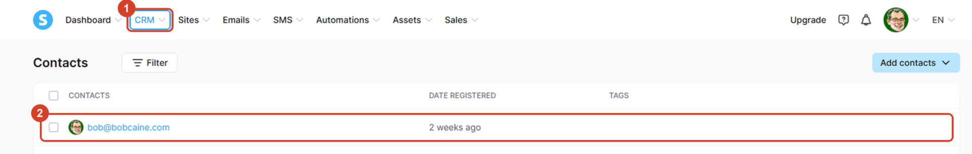 Systeme.io's Contacts screen. 1: the CRM menu at the top. 2: the test email address in the contact list.